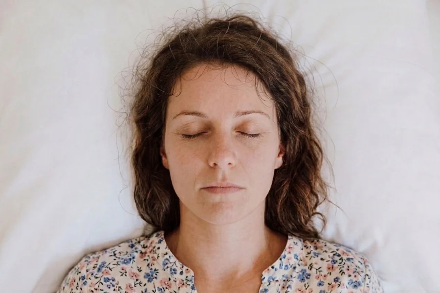 Woman resting with eyes closed during a trauma-informed psilocybin retreat session.